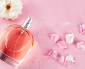 Rose fragrance in an elegant bottle with fresh flowers and petals