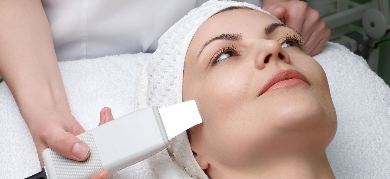 woman getting ultrasound skin cleaning at beauty salon