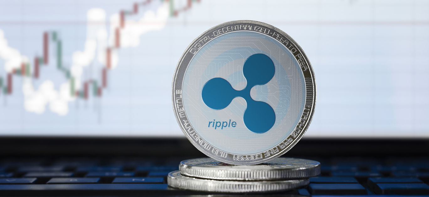 RIPPLE (XRP) cryptocurrency; physical concept ripple coin on the background of the chart