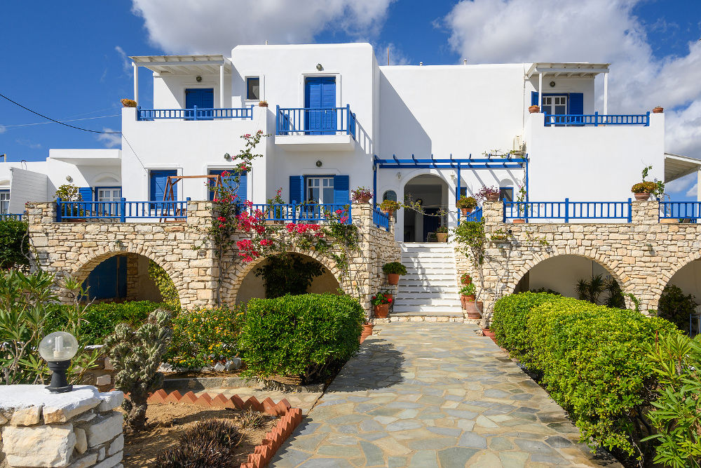 Typical whitewashed Greek villa with blue windows in the Cycladic style on Paros island. Greece