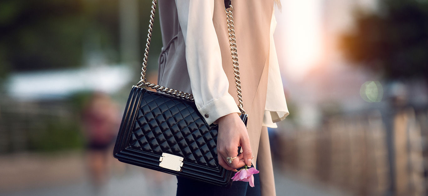 Close up of stylish female black leather bag outdoors. Fashionable and luxury style expensive female bag.