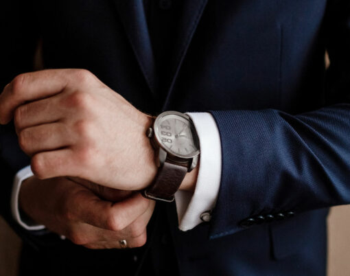 businessman checking time on his wrist watch, man putting clock on hand, groom getting ready in the morning before wedding ceremony. man puts on a watch. selective focus