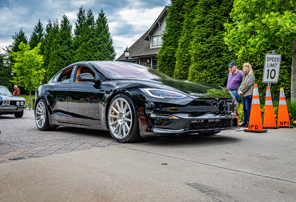 Low perspective front corner view of a 2022 Tesla Model S Plaid Sedan leaving a local car show.