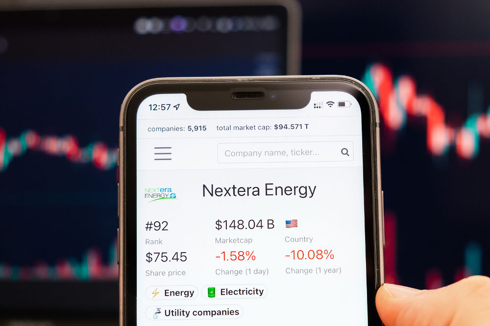 Nextera Energy stock price on the screen of cell phone in mans hand