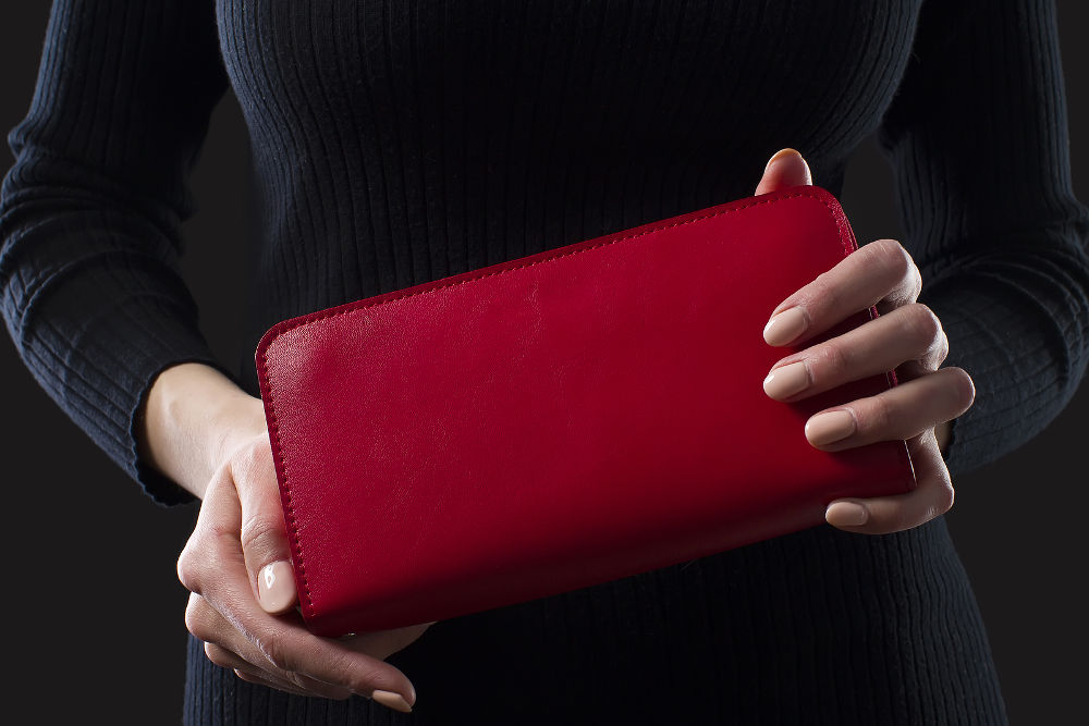 Red leather wallet in female hands.Red Leather Purse
