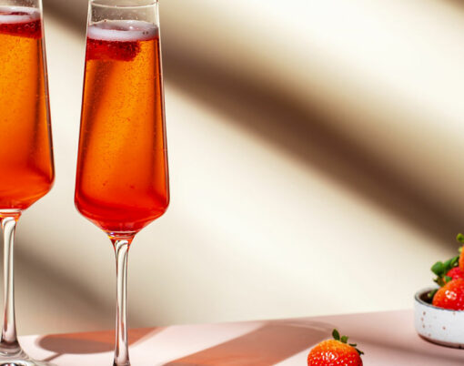 Rossini summer alcoholic cocktail drink with sparkling wine or prosecco, strawberry puree and ice in champagne glasses