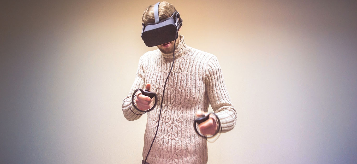 Man uses VR-headset display with headphones for virtual reality game in office