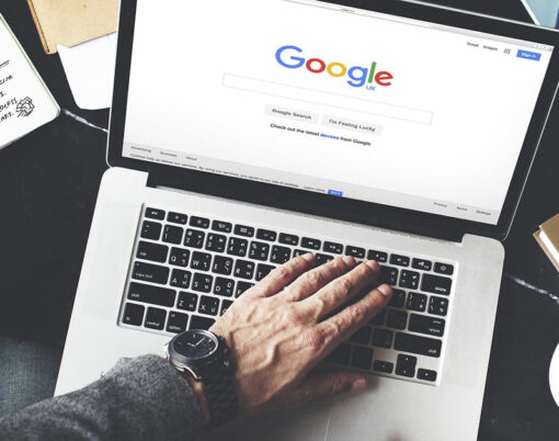 Young Man Browsing Google Website on her Laptop