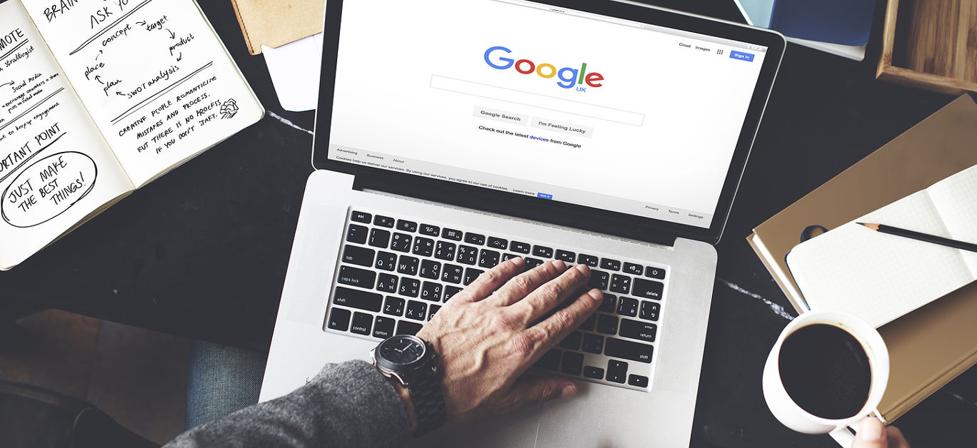 Young Man Browsing Google Website on her Laptop