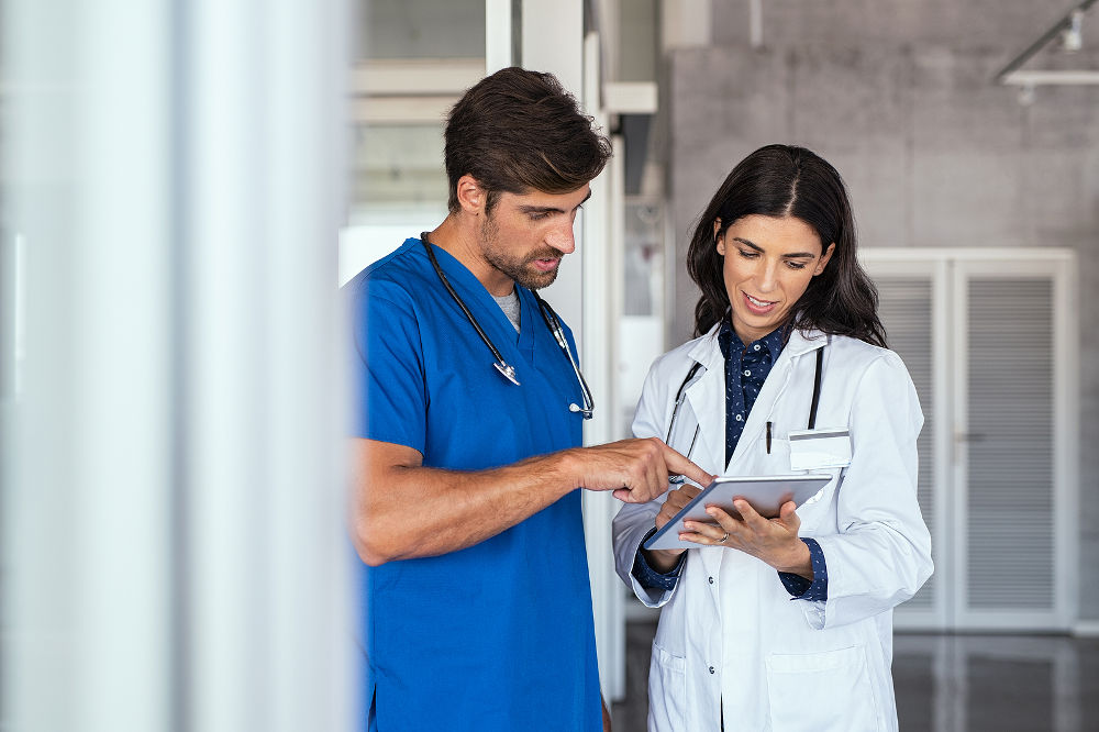 Doctor and nurse discussing over a medical report in hospital