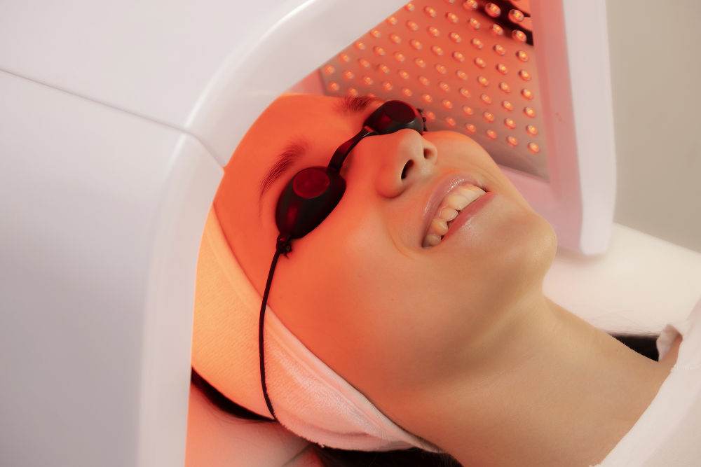 LED face therapy in cosmetology. Photo of LED therapy in red light.