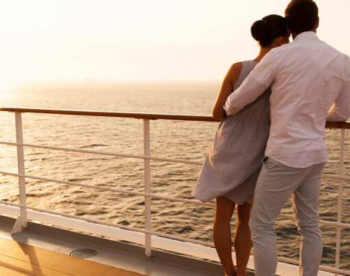 back view of young couple hugging at sunset on cruise ship