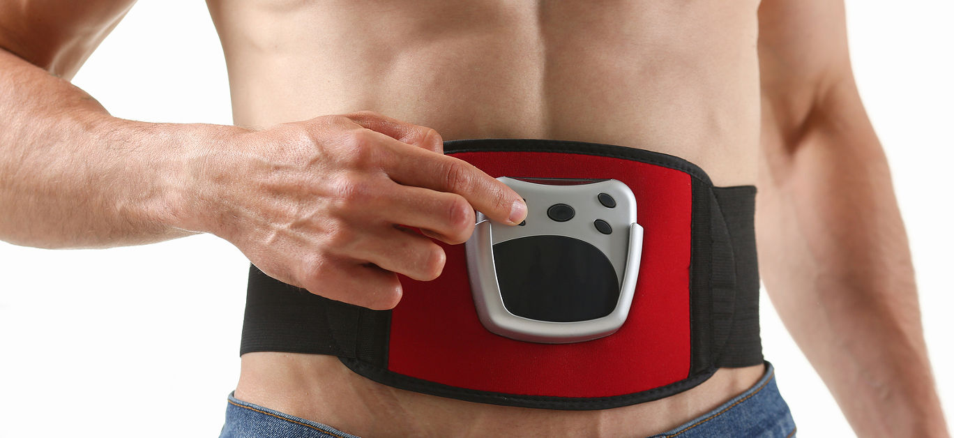 Athletic folded man uses an electric belt simulator for training a press