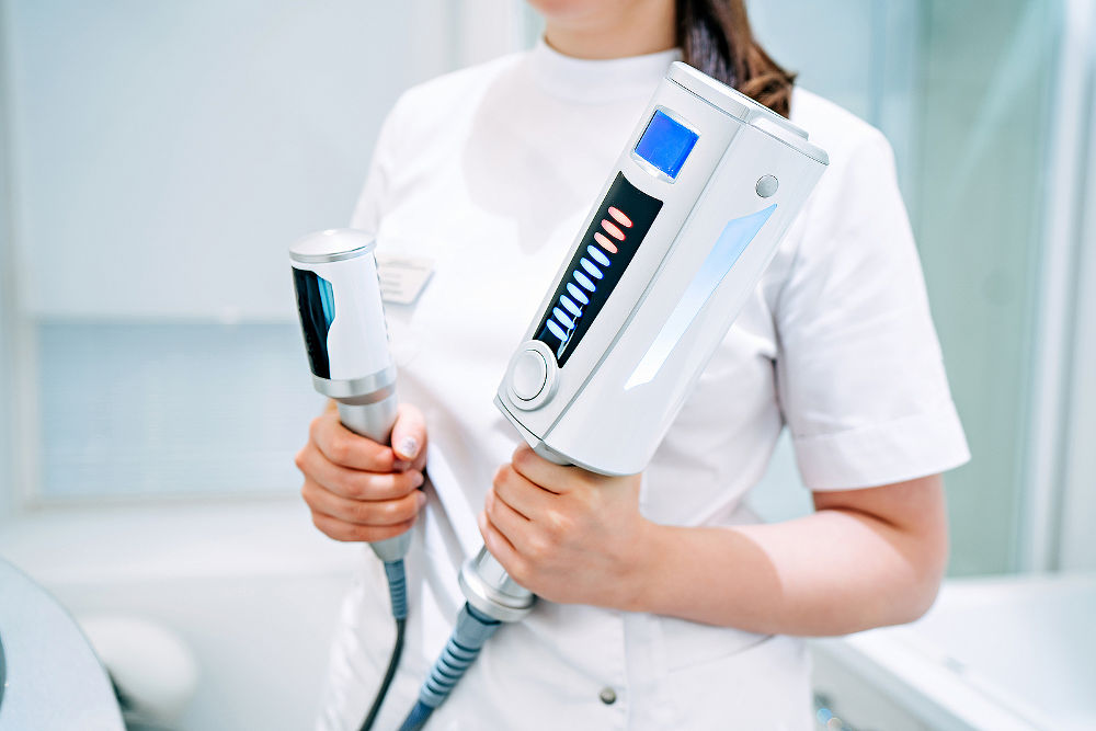 cosmetologist holds in hands an endosphere therapy apparatus, for face and body