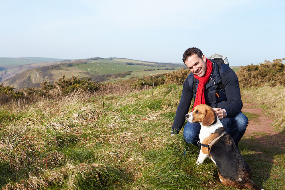 Man With Dog Walking Along Coastal Path