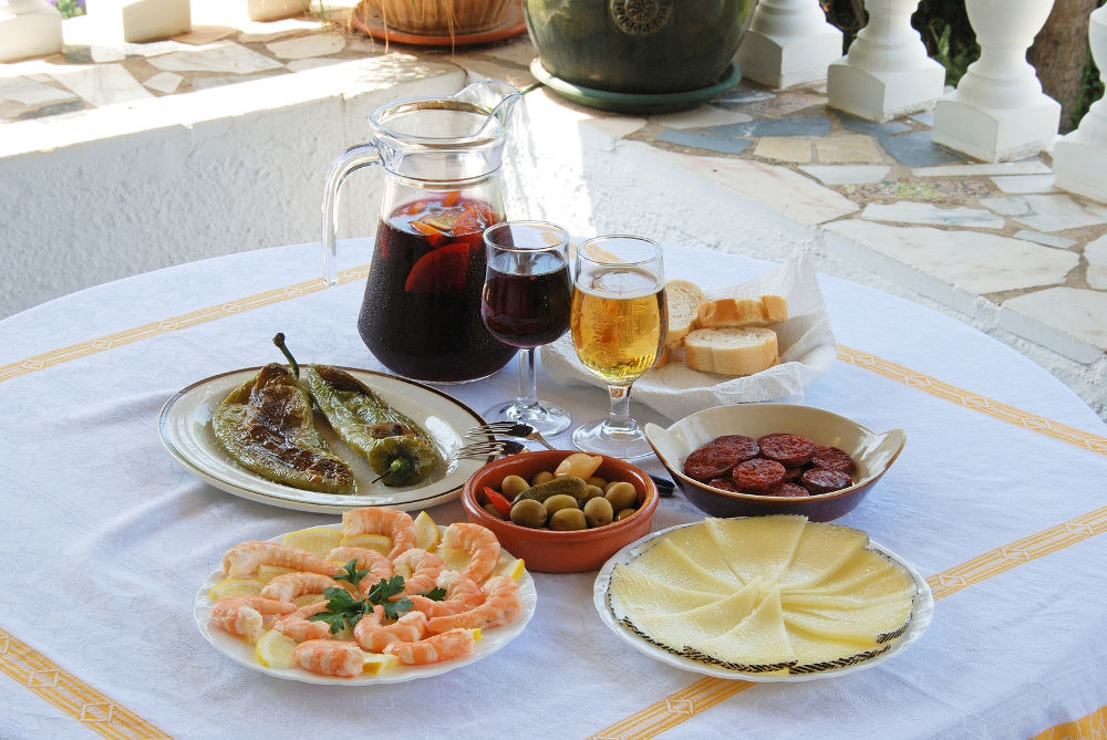 A selection of tapas with sangria and beer Fried green peppers olive cocktail Chorizo slices Sliced Manchego cheese Prawns Costa del Sol Malaga Province Andalucia Spain Western Europe.