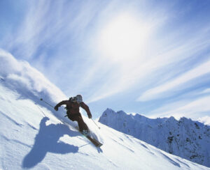 Full length of skier skiing on fresh powder snow