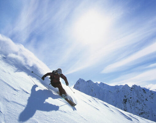 Full length of skier skiing on fresh powder snow