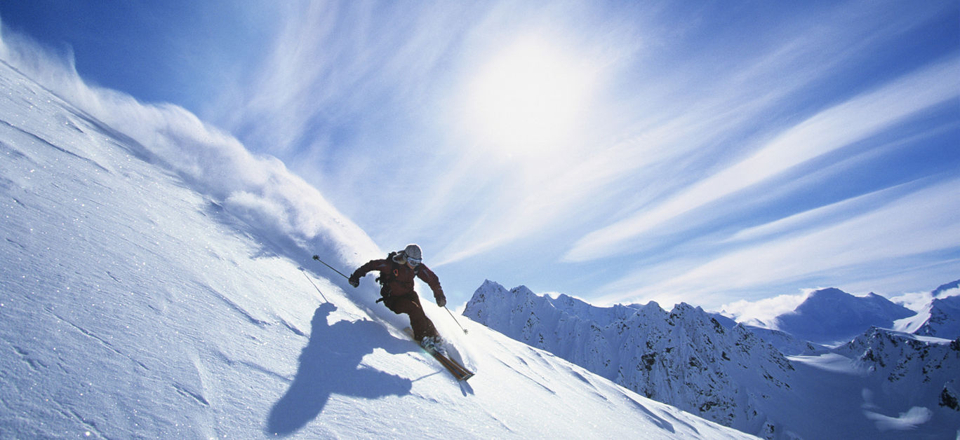 Full length of skier skiing on fresh powder snow