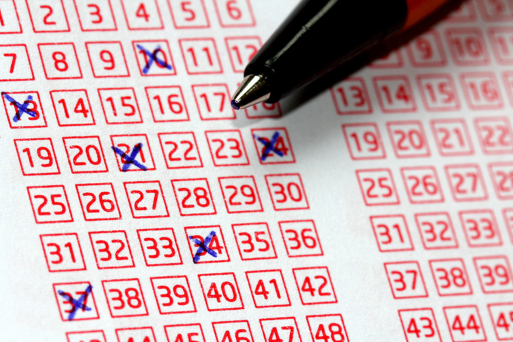 Pen and lucky numbers marked on a lottery coupon shallow depth of field.