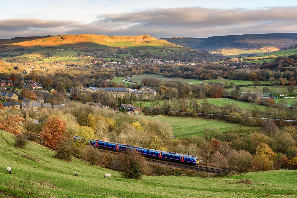 Passanger train passing through british countryside near greater Manchester England.