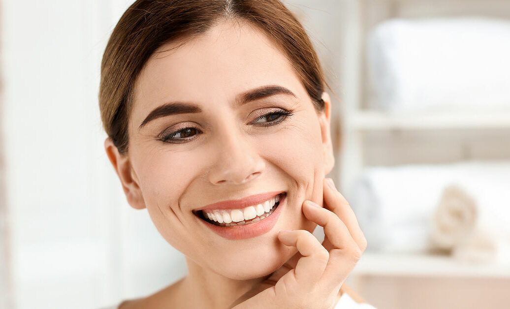 Young woman with beautiful smile indoors. Teeth whitening