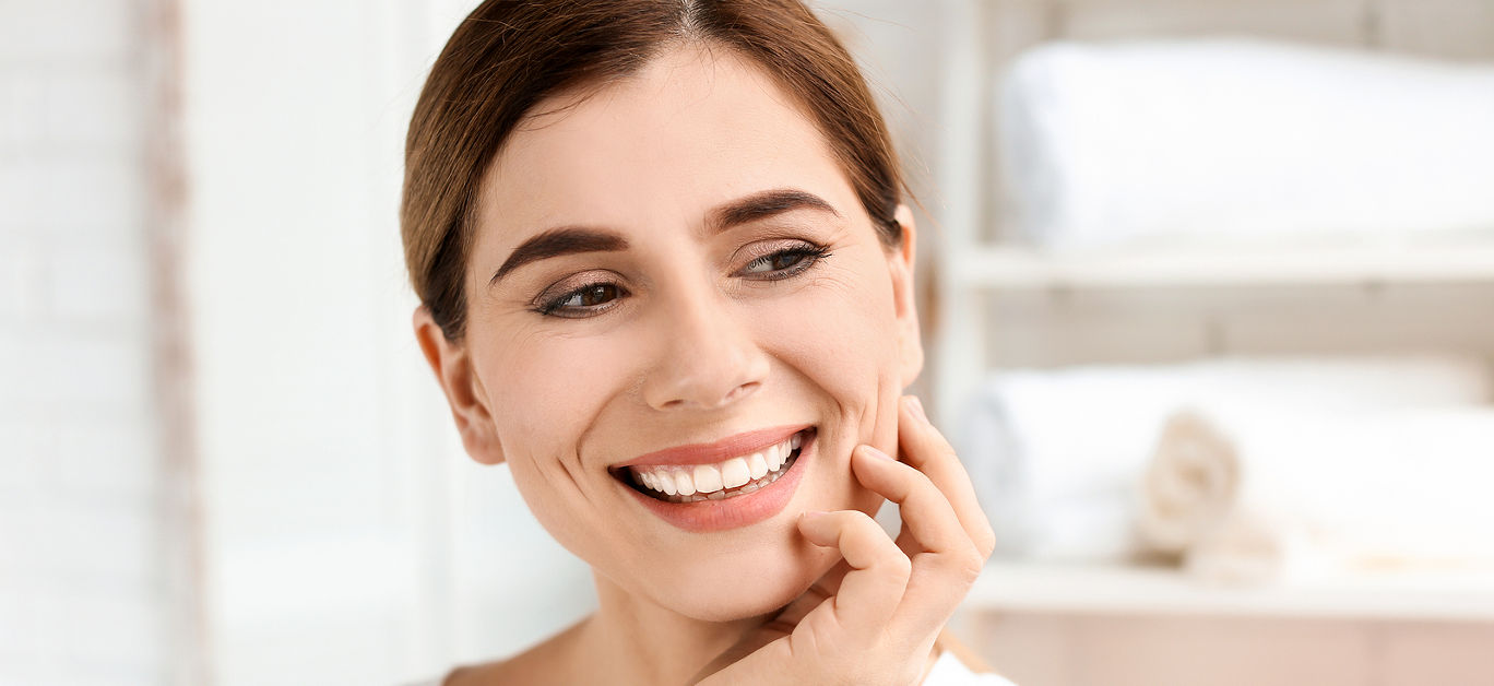 Young woman with beautiful smile indoors. Teeth whitening