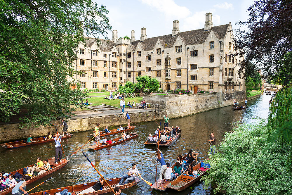 Tourists on punt trip (sightseeing with boat) along River Cam near Old Provost's Lodge in Cambridge University