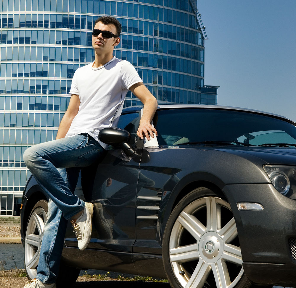 Handsome man standing near the modern sport car