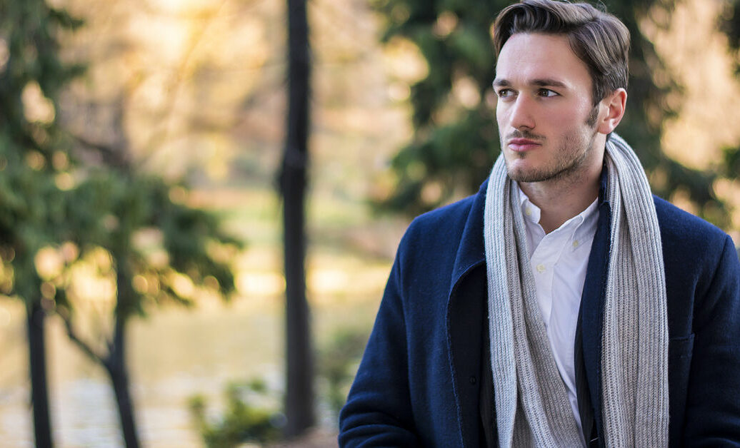 Save Download Preview Handsome young man outdoor in winter fashion, wearing black coat and woolen scarf in city park