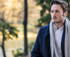 Save Download Preview Handsome young man outdoor in winter fashion, wearing black coat and woolen scarf in city park