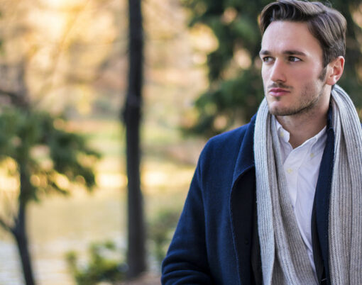 Save Download Preview Handsome young man outdoor in winter fashion, wearing black coat and woolen scarf in city park