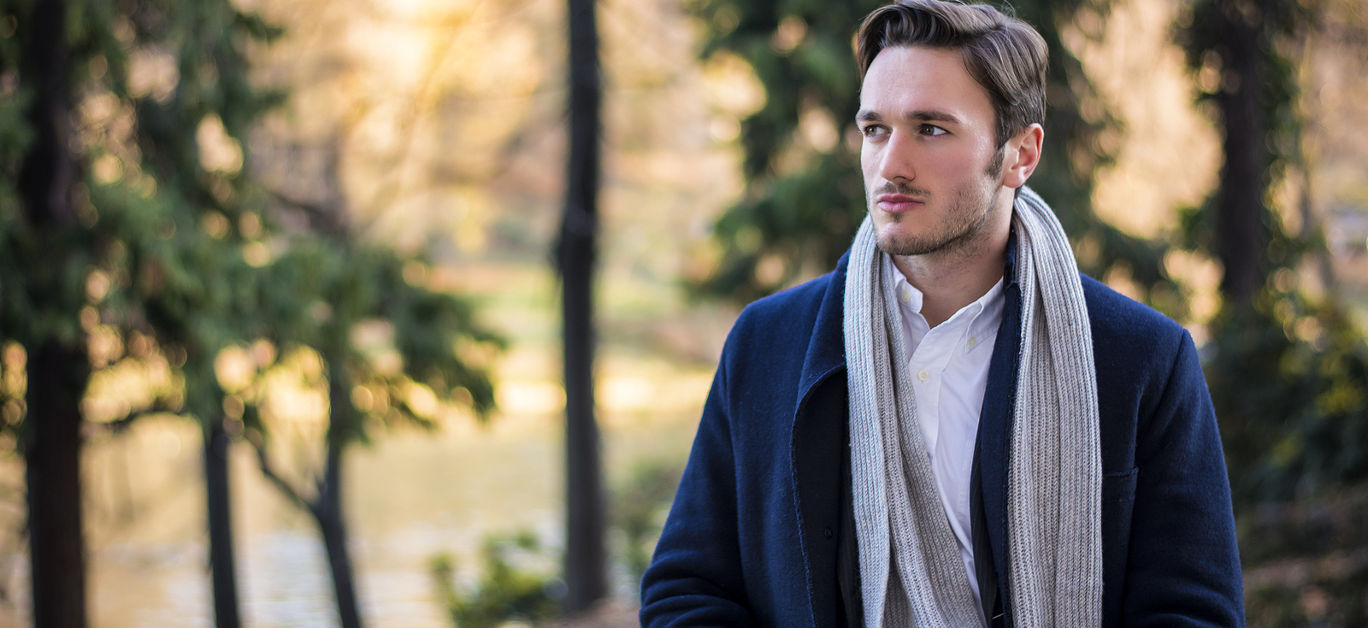 Save Download Preview Handsome young man outdoor in winter fashion, wearing black coat and woolen scarf in city park