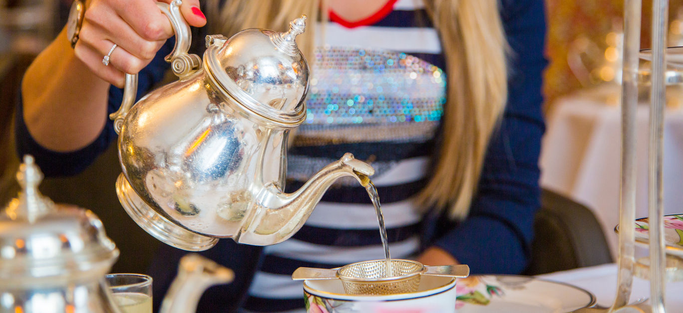 Girl enjoying classical London afternoon tea with english breakfast and snacks.