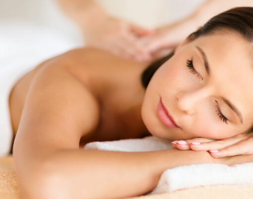 health, beauty, resort and relaxation concept - beautiful woman with closed eyes in spa salon getting massage