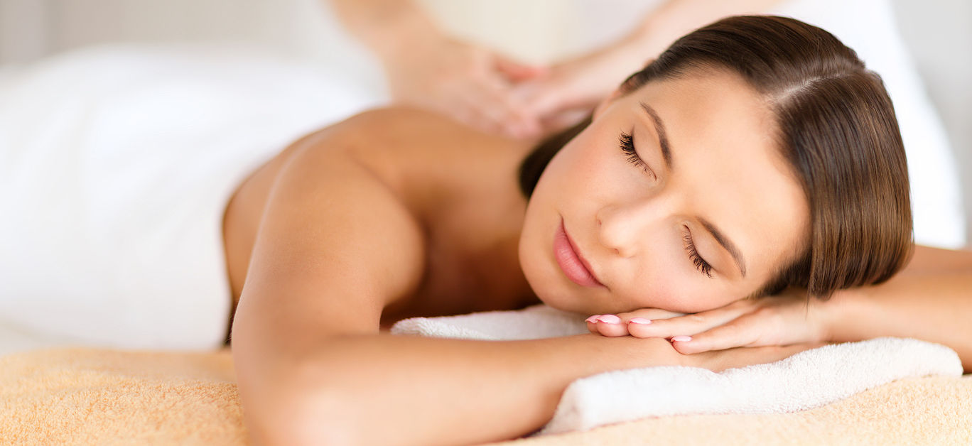 health, beauty, resort and relaxation concept - beautiful woman with closed eyes in spa salon getting massage