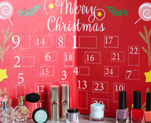 Advent calendar with different cosmetics and perfumes on light grey table. Presents for Christmas