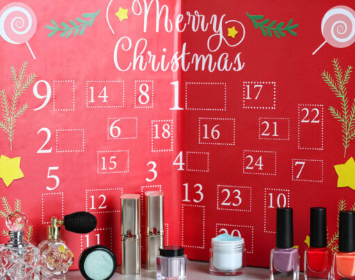 Advent calendar with different cosmetics and perfumes on light grey table. Presents for Christmas