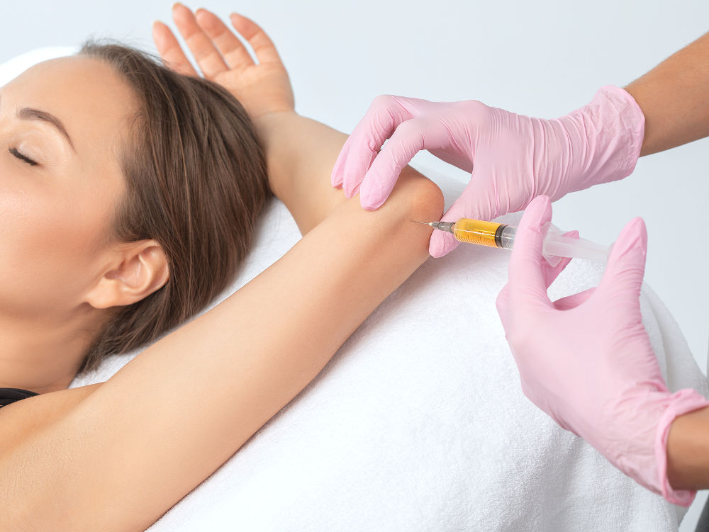 Doctor doing stem cell therapy on a patient\'s elbow after the injury