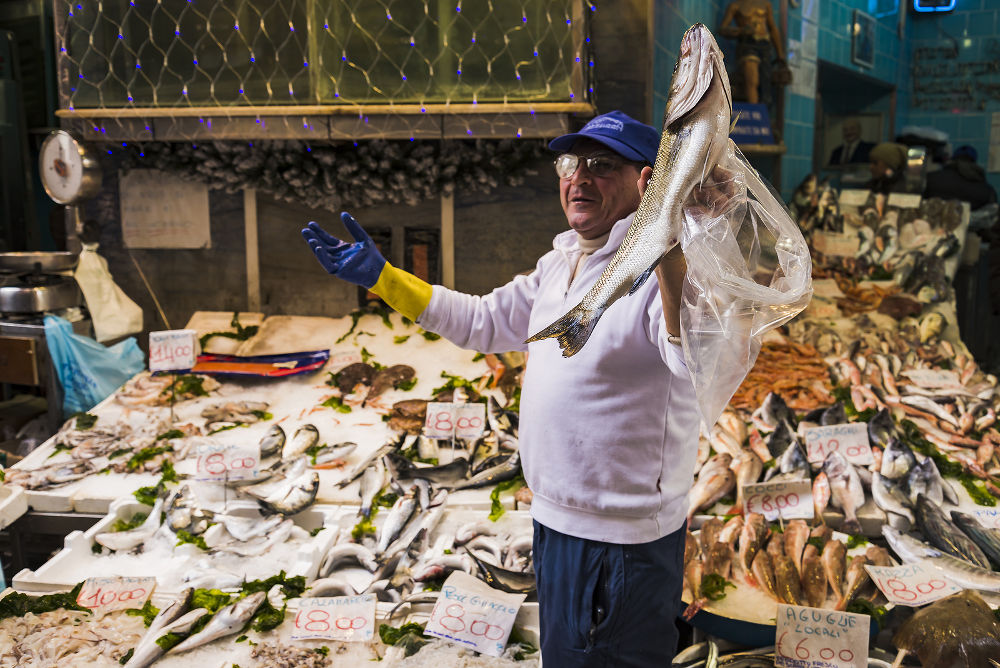 Fish seller show a fish in a market on December 14, 2014 in Naples, Italy