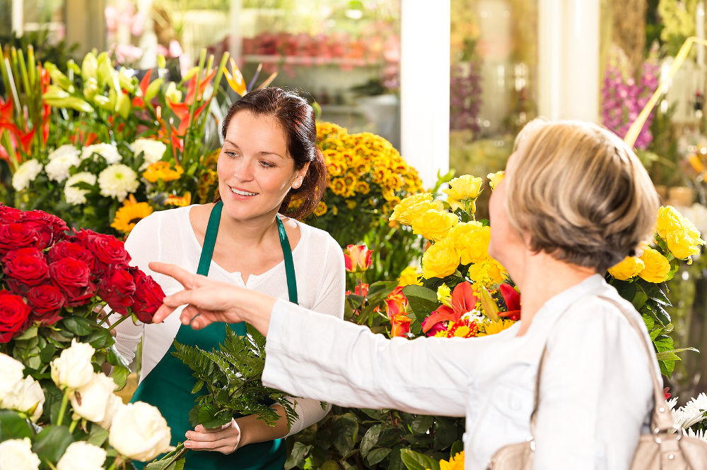 Senior customer buying red roses flower shop florist women working