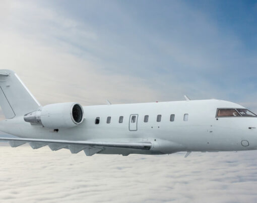 White private jet fly in the air above the clouds