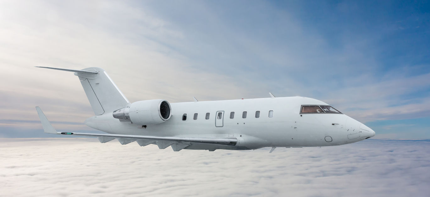 White private jet fly in the air above the clouds