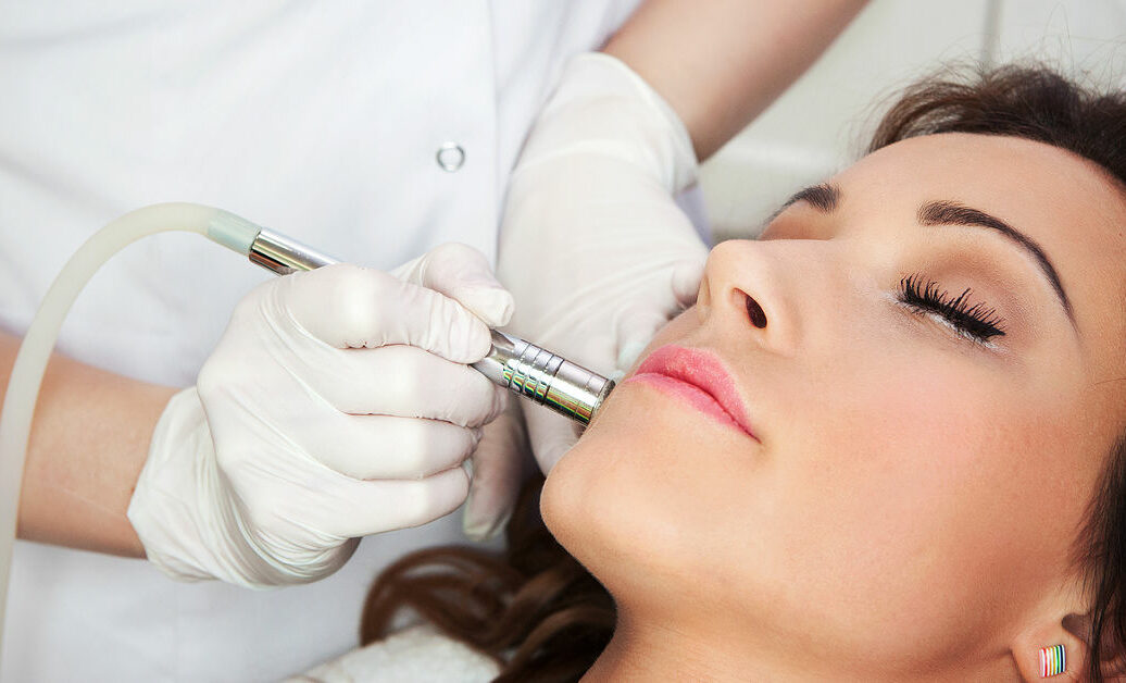 Woman getting laser face treatment in medical spa center, skin rejuvenation concept