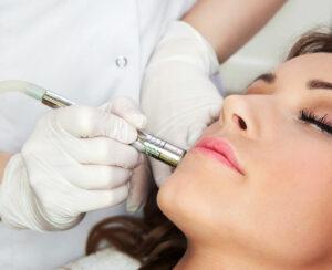 Woman getting laser face treatment in medical spa center, skin rejuvenation concept