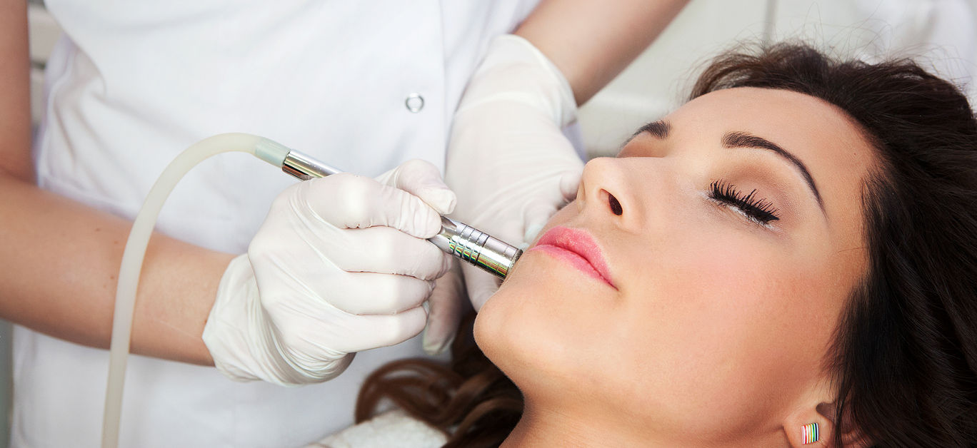 Woman getting laser face treatment in medical spa center, skin rejuvenation concept