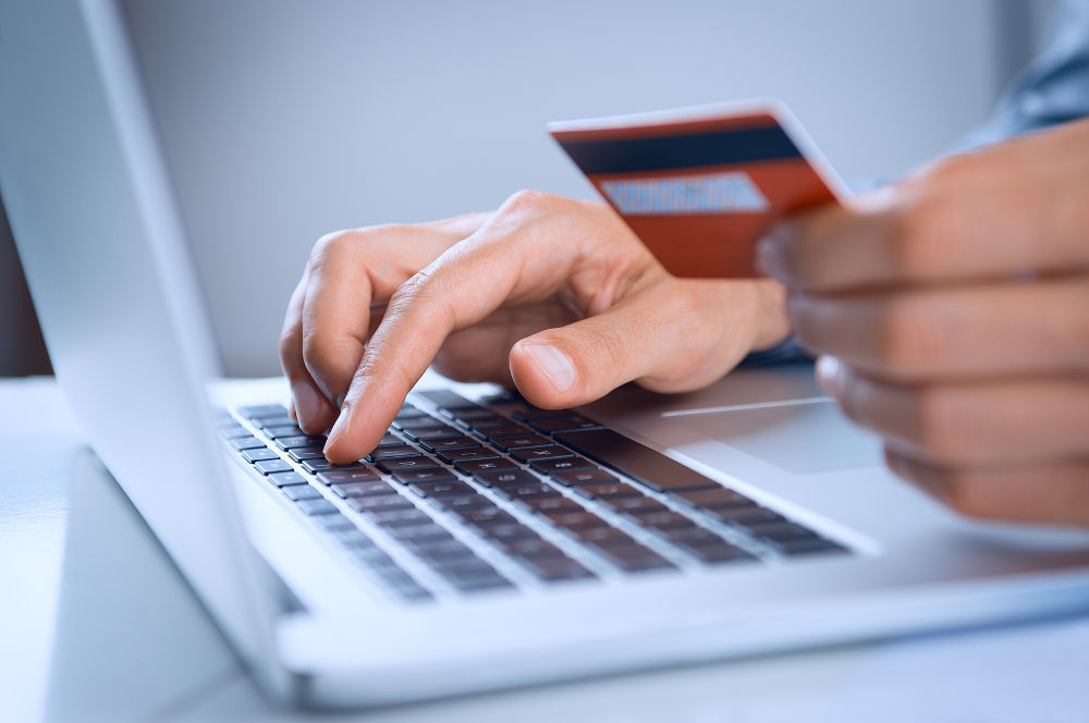 Close Up Of A Man Shopping Online Using Laptop With Credit Card