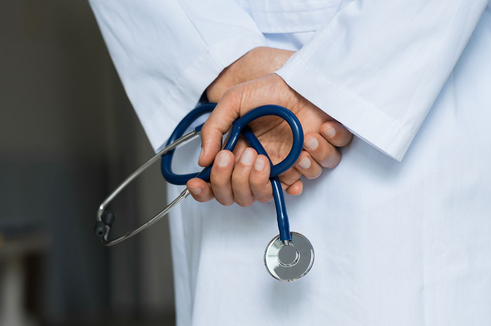 Close up of hands of doctor holding stethoscope in a hospital