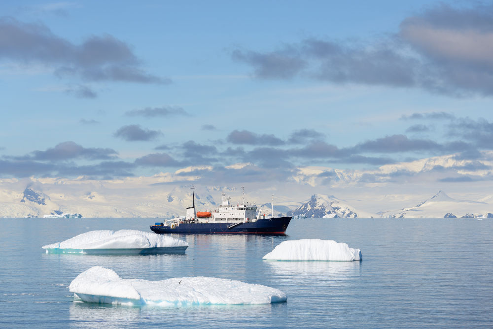 Expedition ship with iceberg in Antarctic sea