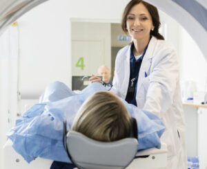 Female Doctor Looking At Patient Undergoing CT Scan